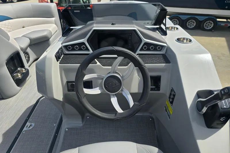 Slide: The Image of Steering console of 2022 Manitou 23 Encore RF pontoon boat, featuring modern controls and seating. - 12