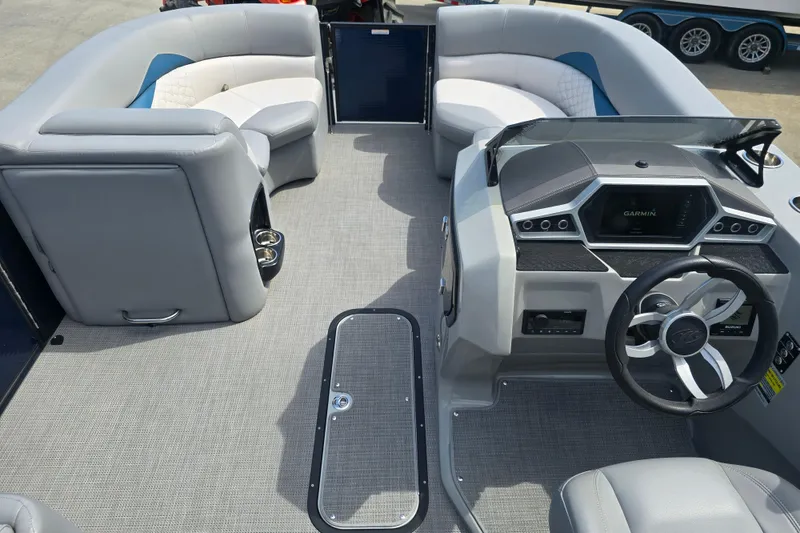 Slide: The Image of 2022 Manitou 23 Encore RF boat interior with modern helm and spacious seating. - 13
