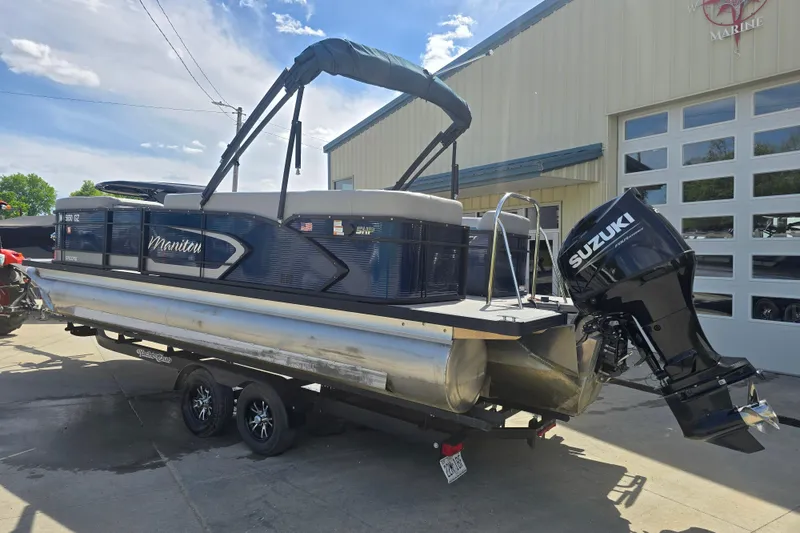 Slide: The Image of 2022 Manitou 23 Encore RF pontoon boat with Suzuki outboard motor on trailer. - 2