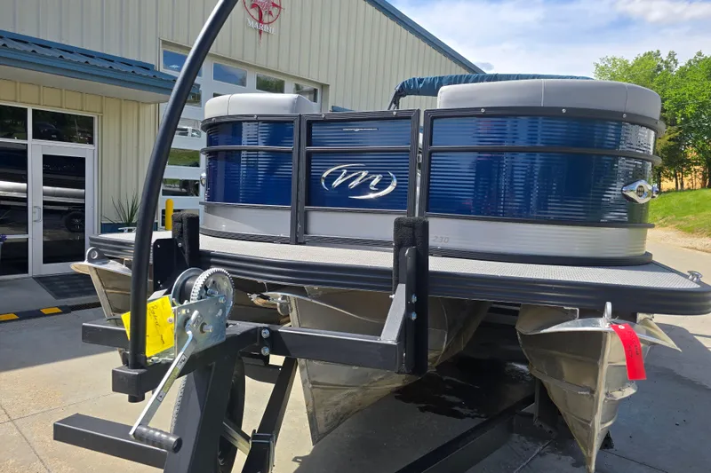 Slide: The Image of 2022 Manitou 23 Encore RF pontoon boat on trailer outside a marine dealership. - 6
