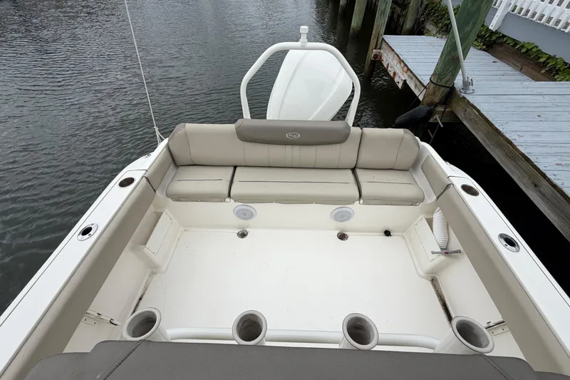 Slide: The Image of 2022 Key West 239 FS boat interior with cushioned seating and cup holders. - 11