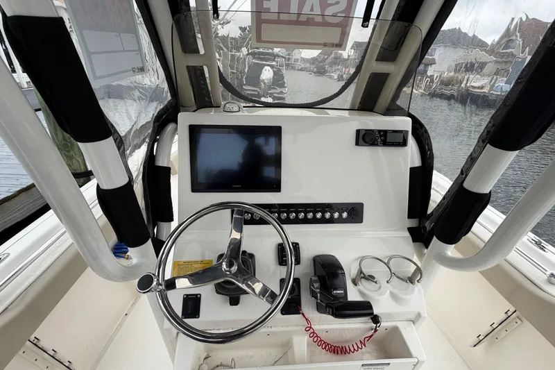 Slide: The Image of 2022 Key West 239 FS boat dashboard with steering wheel and navigation controls. - 13