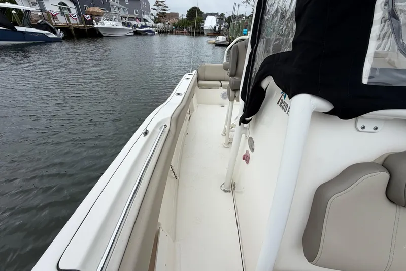 Slide: The Image of 2022 Key West 239 FS boat docked in a marina, showcasing sleek design and comfortable seating. - 16