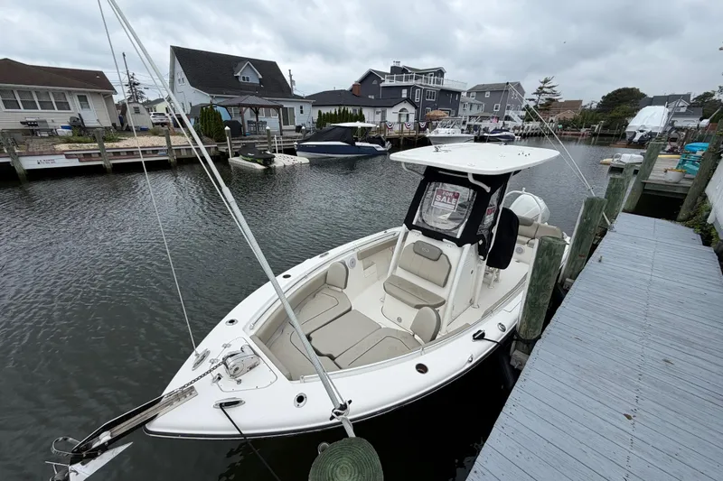 Slide: The Image of 2022 Key West 239 FS boat docked, for sale sign visible, overcast sky. - 6