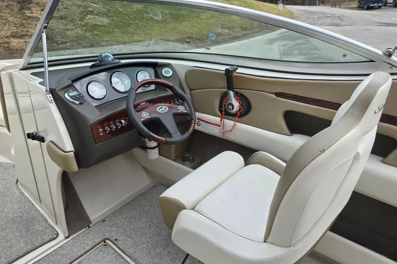 Slide: The Image of Interior of 2007 Sea Ray 210 Select boat, featuring steering wheel and dashboard controls. - 12