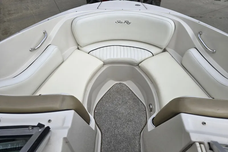 Slide: The Image of 2007 Sea Ray 210 Select boat interior with white cushioned seating and carpeted floor. - 18