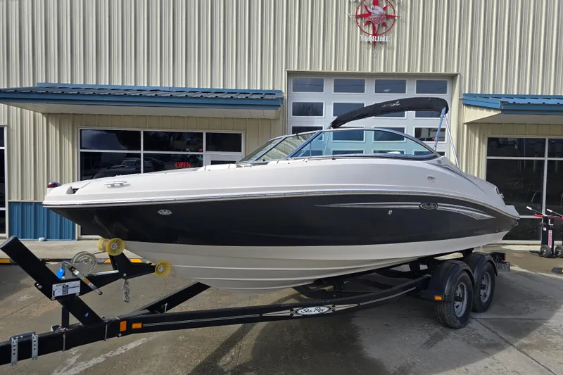 Slide: The Image of 2007 Sea Ray 210 Select boat on trailer outside a marine shop. - 2