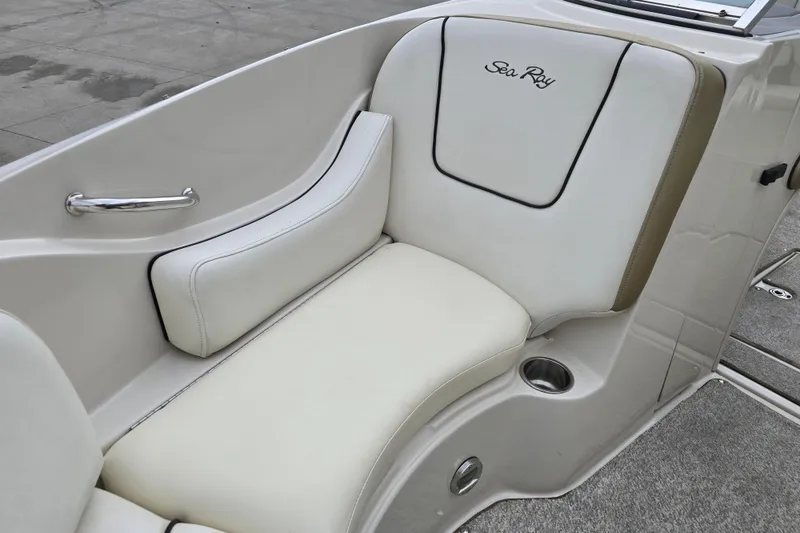 Slide: The Image of 2007 Sea Ray 210 Select boat interior with white cushioned seating and cup holder. - 20