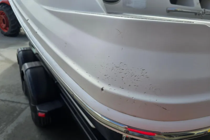 Slide: The Image of 2007 Sea Ray 210 Select boat with visible hull scratches on a trailer. - 24