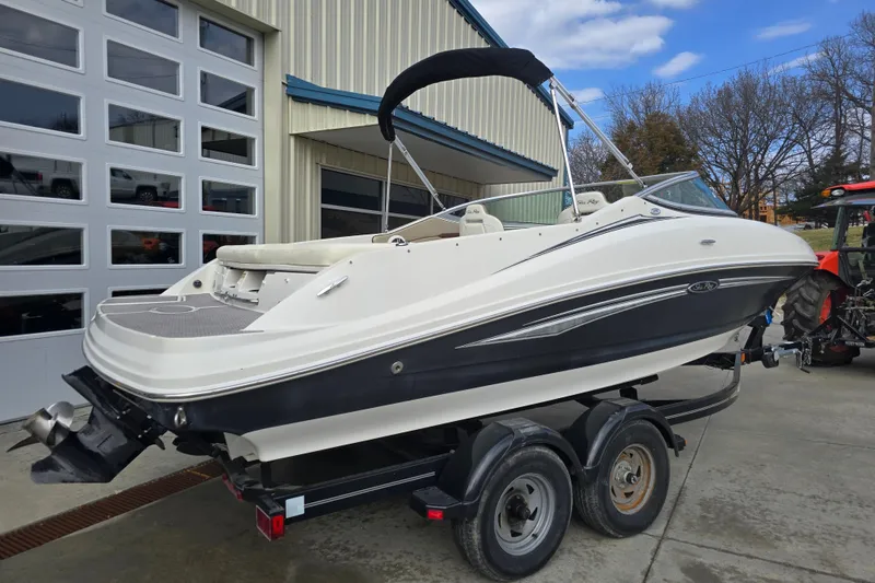 Slide: The Image of 2007 Sea Ray 210 Select boat on trailer, parked outside a garage. - 6