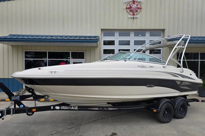 The Image of 2003 Sea Ray 220 Sundeck boat on trailer outside marine shop. - 0