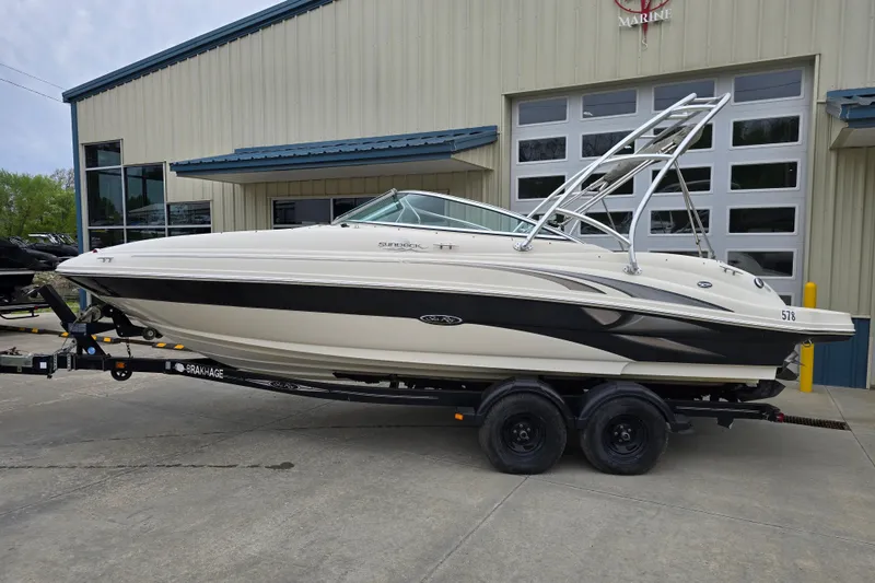 Slide: The Image of 2003 Sea Ray 220 Sundeck boat on trailer, parked outside a marine facility. - 1
