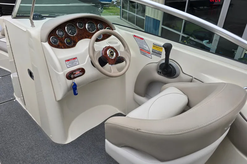 Slide: The Image of 2003 Sea Ray 220 Sundeck helm with steering wheel and control panel. - 10