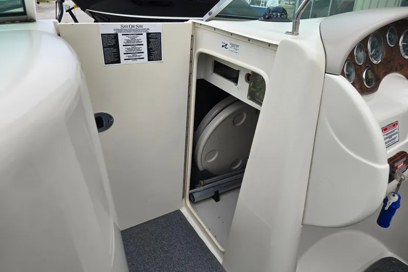 Slide: The Image of 2003 Sea Ray 220 Sundeck interior storage compartment with visible dashboard and controls. - 11