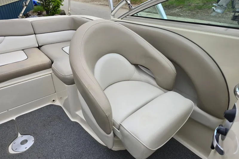 Slide: The Image of 2003 Sea Ray 220 Sundeck interior with beige seating and carpeted flooring. - 13