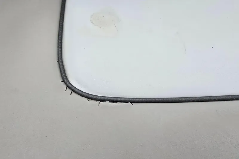 Slide: The Image of Frayed upholstery corner on 2003 Sea Ray 220 Sundeck boat seat. - 24