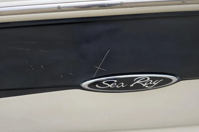 Slide: The Image of Close-up of 2003 Sea Ray 220 Sundeck boat logo with visible scratches. - 30