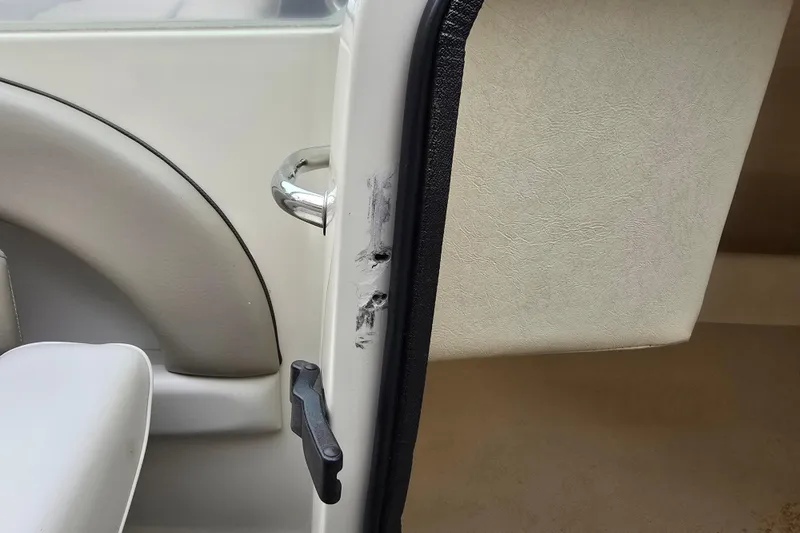 Slide: The Image of 2003 Sea Ray 220 Sundeck interior with visible wear on door edge. - 31