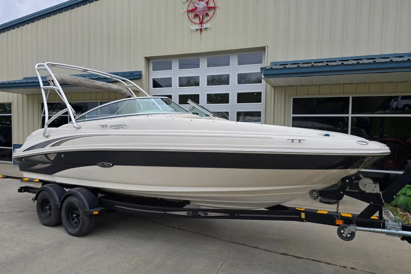 Slide: The Image of 2003 Sea Ray 220 Sundeck boat on trailer outside a marine building. - 6