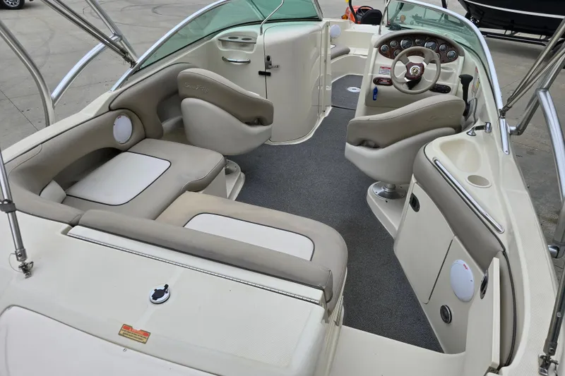 Slide: The Image of 2003 Sea Ray 220 Sundeck interior with beige seating and modern dashboard. - 7