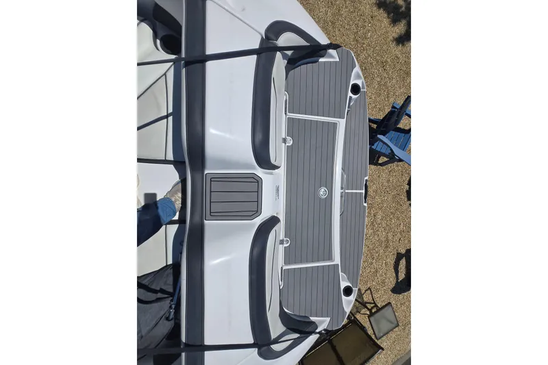 Slide: The Image of 2018 Yamaha Boats AR210 swim platform with gray seating and deck, outdoor setting. - 17