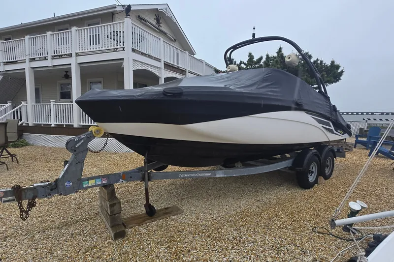 Slide: The Image of 2018 Yamaha AR210 boat on trailer, covered, near a large house. - 6