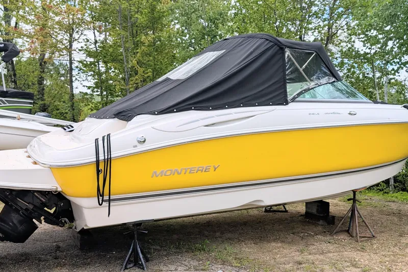 Slide: The Image of 2007 Monterey 248LS Montura Bowrider, yellow hull, covered, on stands, surrounded by trees. - 1