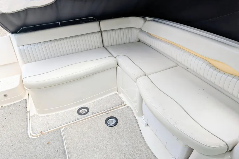 Slide: The Image of 2007 Monterey 248LS Montura Bowrider interior seating with white upholstery and carpeted flooring. - 7