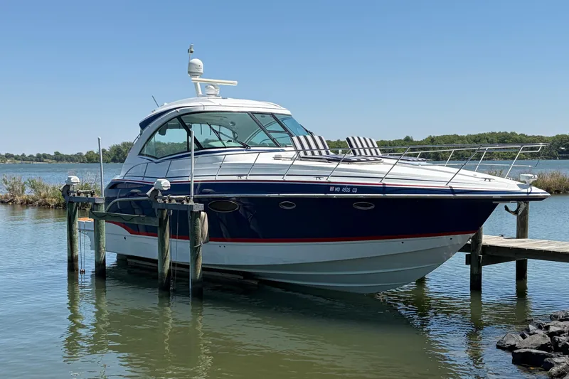 The Image of 2011 Formula 45 Yacht docked on a serene lake under clear blue skies. - 1