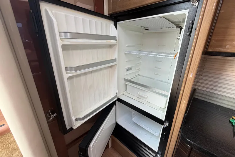 Slide: The Image of Open refrigerator inside 2011 Formula 45 Yacht, showcasing spacious interior and shelving. - 23