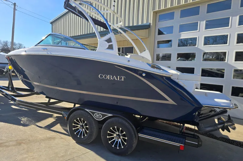 Slide: The Image of 2020 Cobalt R3 boat on trailer, parked outside a garage. - 2