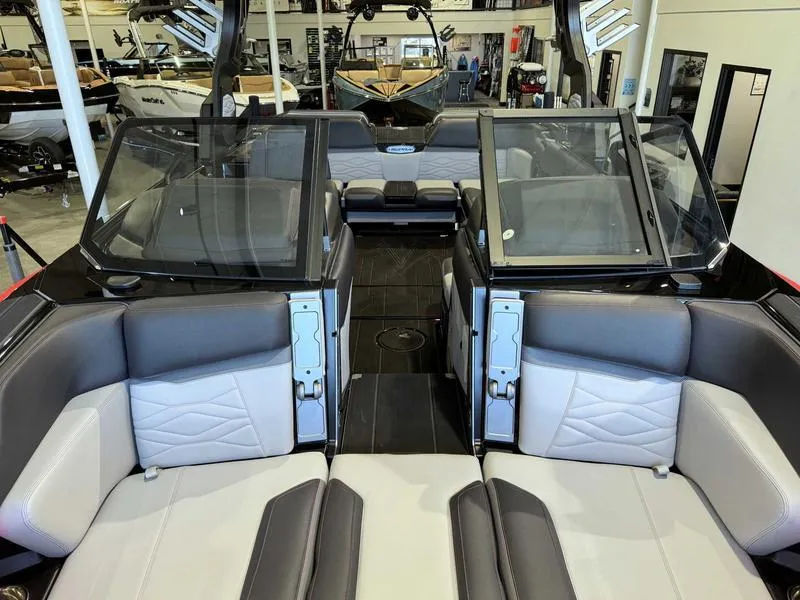 Slide: The Image of 2025 Supra SA boat interior with luxurious seating and modern design in a showroom. - 12