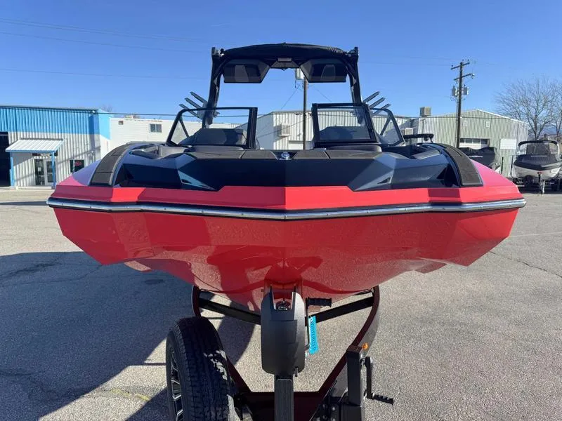 Slide: The Image of 2025 Supra SA boat in red and black, parked on a trailer in an industrial area. - 3