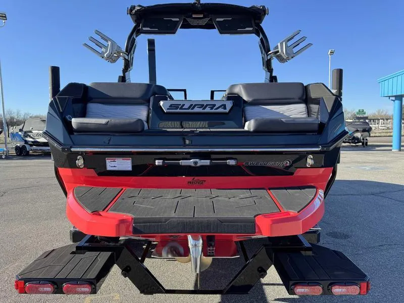 Slide: The Image of 2025 Supra SA boat rear view with seating and wakeboard racks. - 6