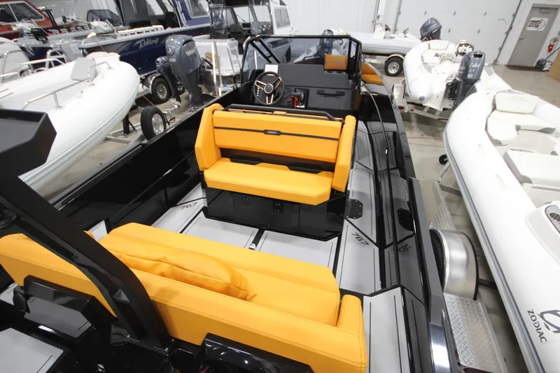 Slide: The Image of 2026 Iron 767 boat with vibrant orange seating, showcased in a showroom among other boats. - 12