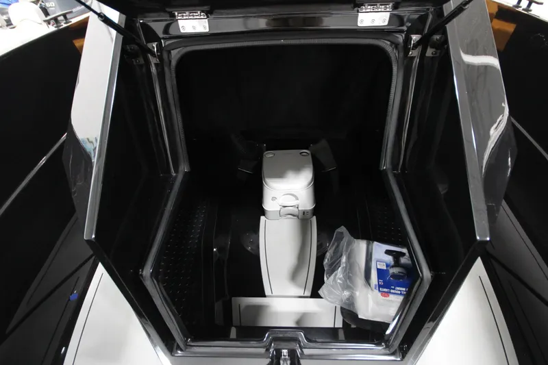 Slide: The Image of Open storage compartment of Iron 767 boat, featuring a portable toilet and cleaning supplies. - 26