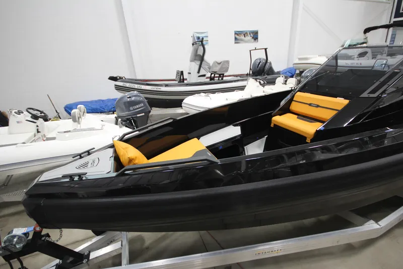 Slide: The Image of 2026 Iron 767 boat with sleek black design and orange seating, displayed indoors. - 4