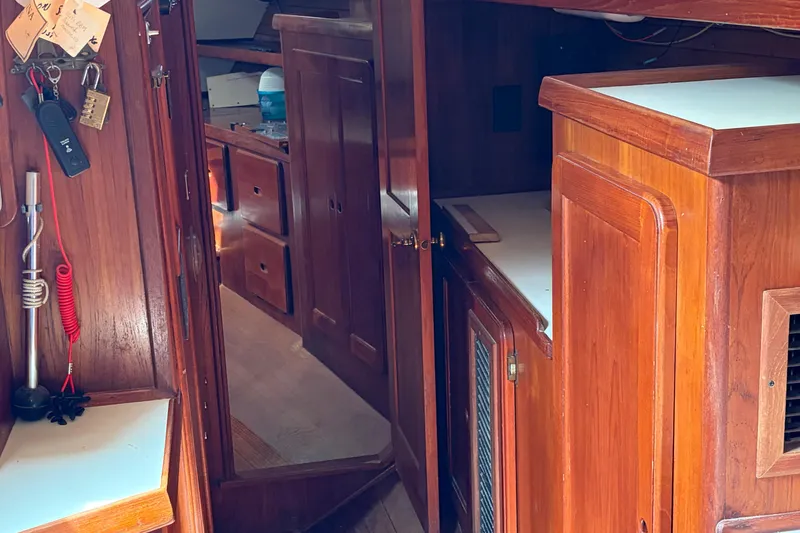 Slide: The Image of Interior of a 1987 Morgan 43 sailboat with wooden cabinetry and storage compartments. - 14