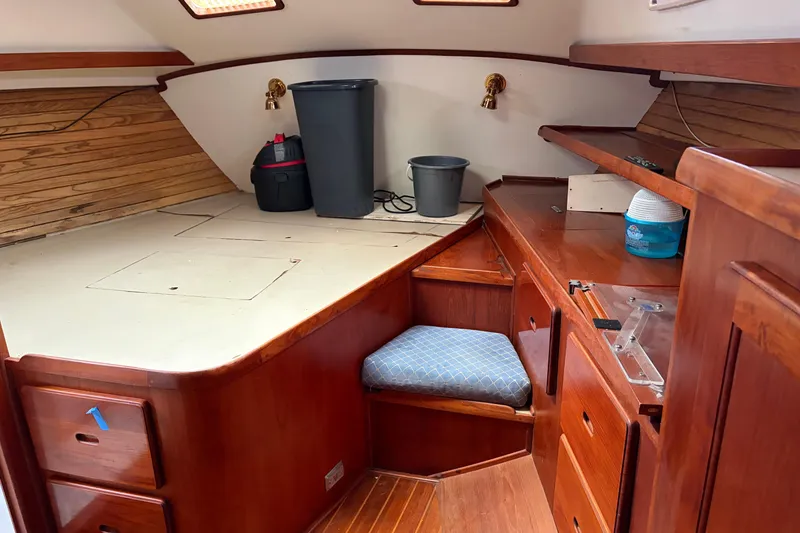 Slide: The Image of 1987 Morgan 43 yacht interior with wooden cabinetry and seating area. - 15