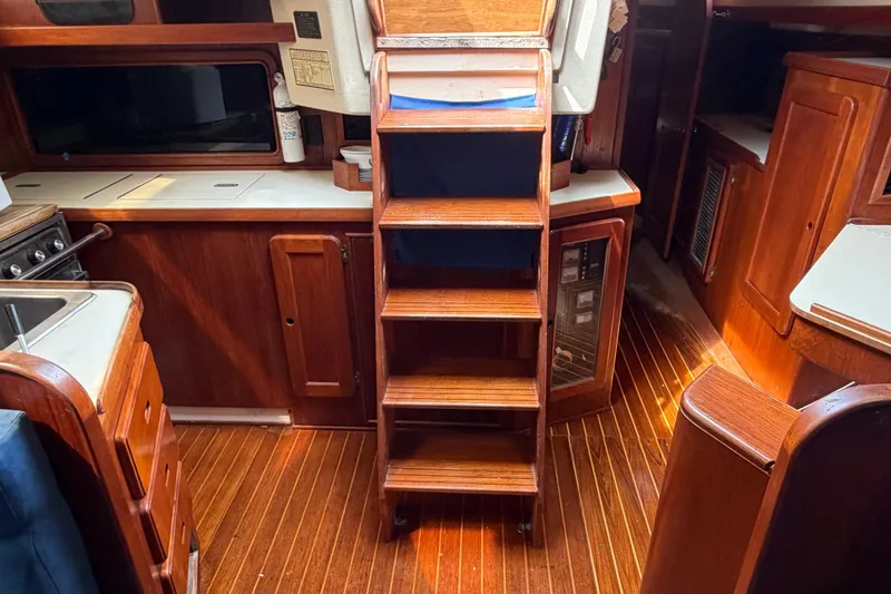 Slide: The Image of Interior of a 1987 Morgan 43 sailboat with wooden cabinetry and stairs. - 17