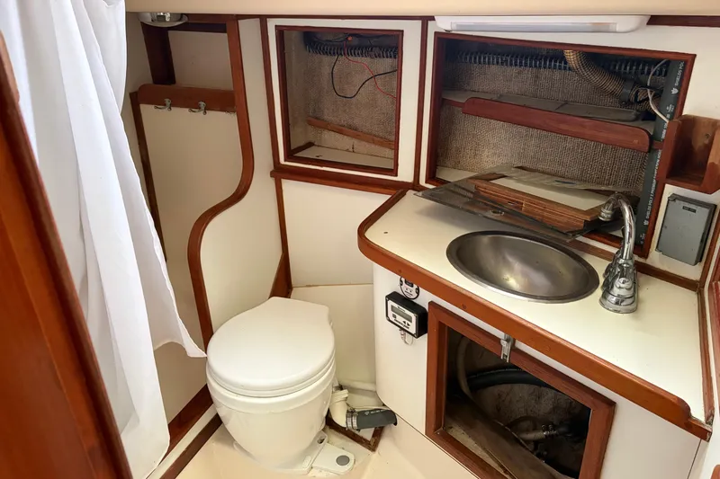 Slide: The Image of 1987 Morgan 43 yacht bathroom with toilet, sink, and wooden cabinetry. - 20