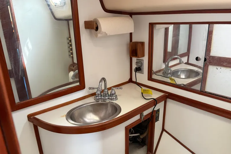 Slide: The Image of 1987 Morgan 43 yacht bathroom with sink, mirror, and wooden accents. - 21