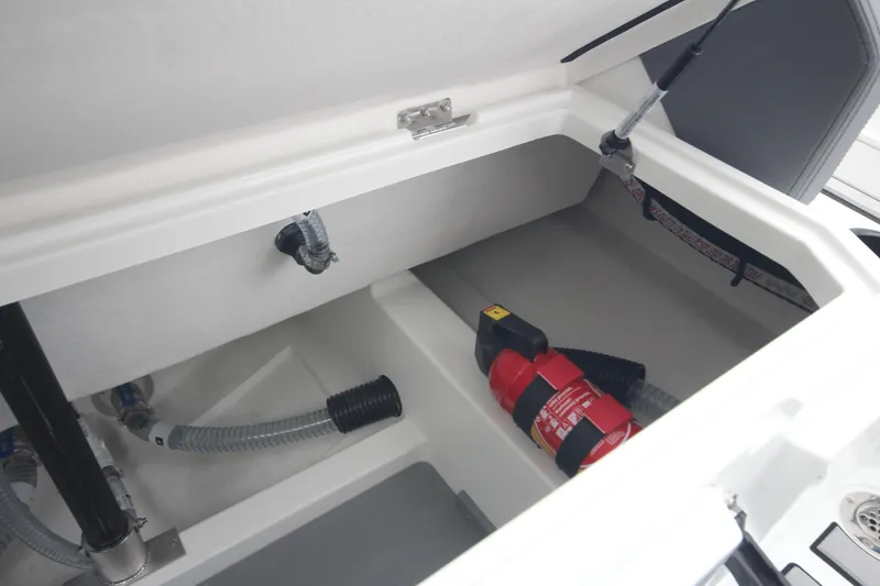 Slide: The Image of Storage compartment of Iron 767 boat, featuring a fire extinguisher and hoses, 2026 model. - 18