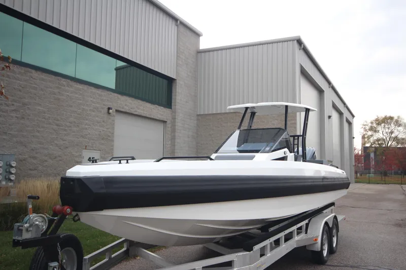 Slide: The Image of Modern Iron 767 boat on trailer, parked outside industrial building, 2026 model. - 3