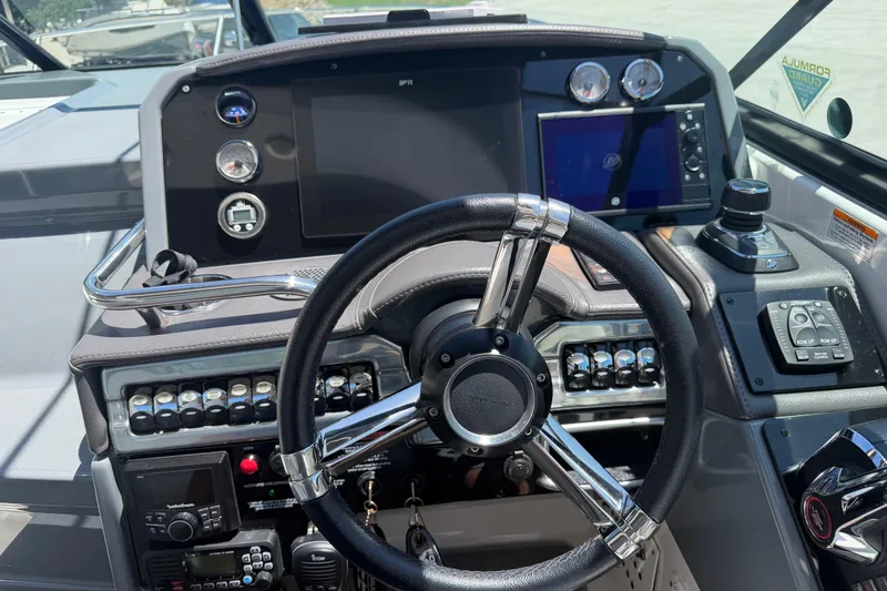 Slide: The Image of Dashboard of a 2022 Formula 310 Sun Sport boat with steering wheel and controls. - 24