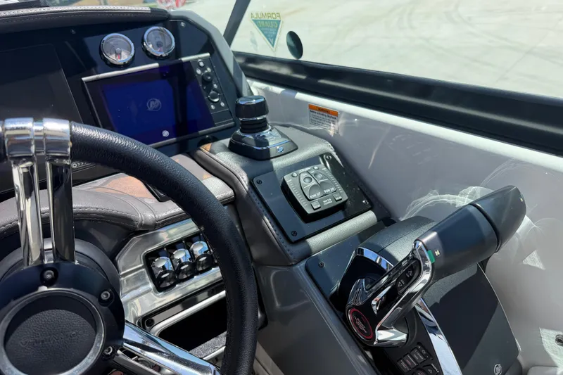 Slide: The Image of Cockpit of 2022 Formula 310 Sun Sport boat with steering wheel and control panel. - 25