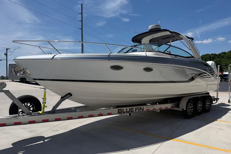 Slide: The Image of 2022 Formula 310 Sun Sport boat on trailer under clear blue sky. - 8