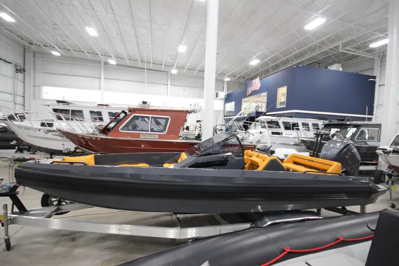 Slide: The Image of Modern IRON 767 boat in showroom, surrounded by various vessels, showcasing sleek design. - 3