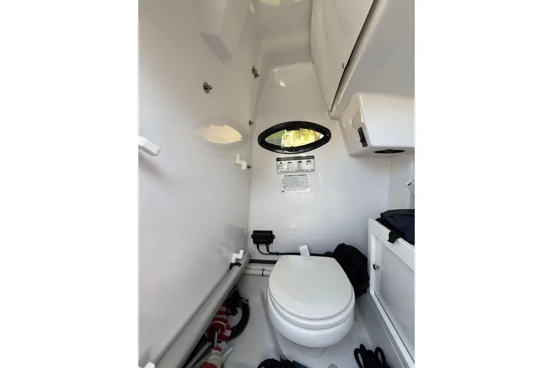 Slide: The Image of 2021 Sportsman Open 252 Center Console boat interior with toilet and storage. - 12