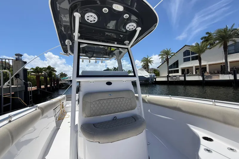 Slide: The Image of 2021 Sportsman Open 252 Center Console boat docked by waterfront homes. - 13